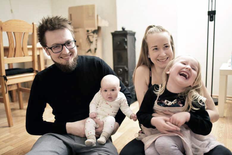 Andreas and Marie sit on the floor with a child on each lap