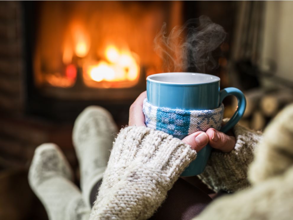 warming up with a cup of tea in front of the fireplace