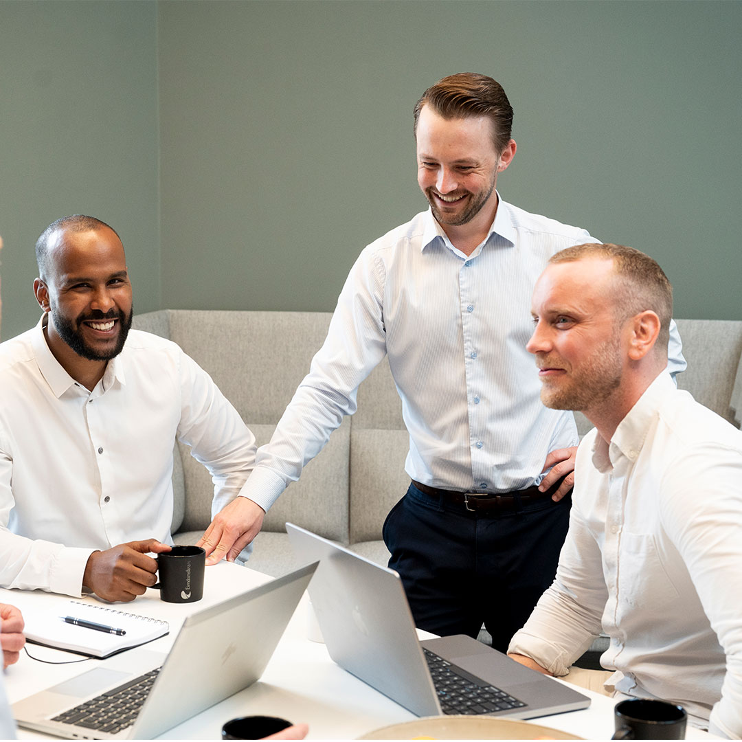 Jonas, Mads og Andreas i Eiendomsfinans. Sitter ved et bord og snakker