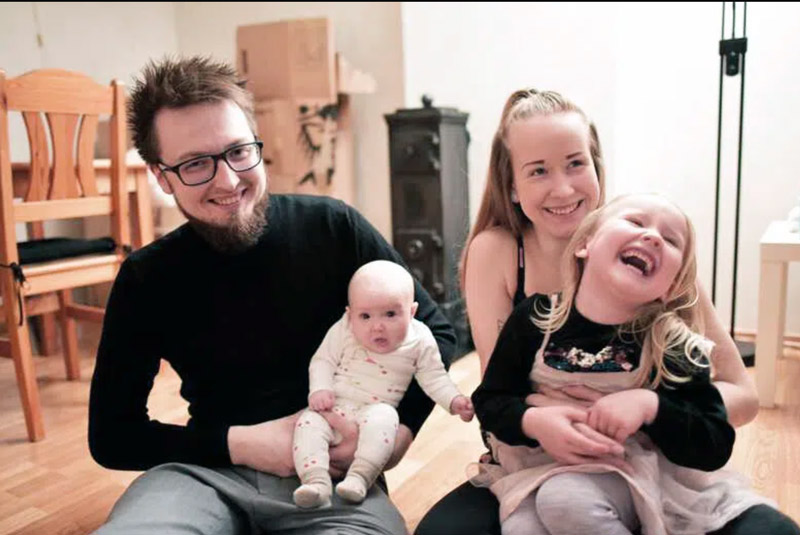 Mor, far og 2 barn som sitter på stuegulvet